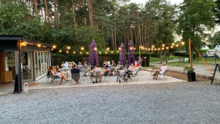 Zona de comedor al aire libre en Camping het Swinnenbos, con huéspedes disfrutando del verano en Bélgica.