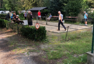 Gäste spielen Boule auf dem Gelände des Camping het Swinnenbos in Flämisch-Brabant, Belgien.