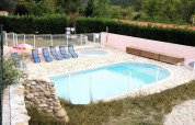 Piscina all'aperto e piscina per bambini con lettini e ombrellone al Camping le Rotja in Occitania, Francia.