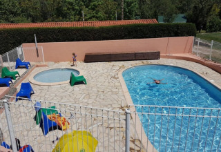 Piscina exterior y piscina infantil con tumbonas en Camping le Rotja, parque vacacional en Occitania, Francia.