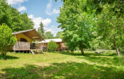 Solrige campinghytter i grønne omgivelser med hængekøje hos Camping Pittoresque, Occitanie, Frankrig.