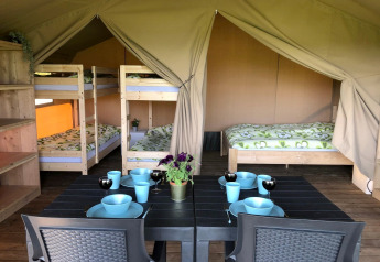 Innenraum eines Safarizelts auf dem Camping Emmen in den Niederlanden mit Betten und Esstisch.