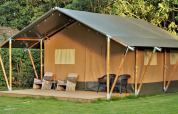 Tienda safari en Camping Gorishoek, Países Bajos, con terraza de madera, sillas y entorno natural.