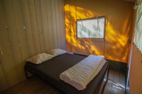 Innenaufnahme eines Schlafbereichs mit Doppelbett im Safarizelt auf Camping Gorishoek, Niederlande.