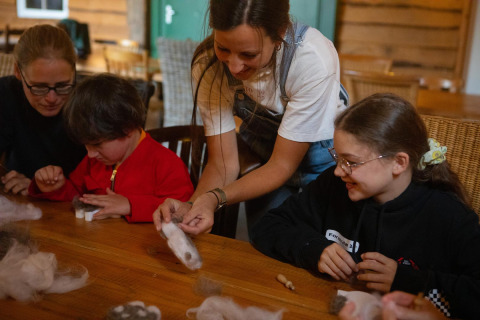 Children and adults enjoy a crafting workshop together at FarmCamps Mariekerke in Zeeland, Netherlands.