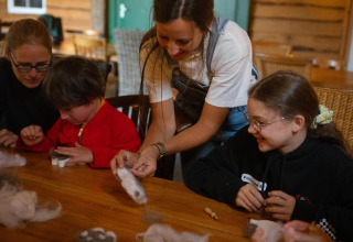 Kinderen en volwassenen doen samen een knutselworkshop bij FarmCamps Mariekerke in Zeeland, Nederland.