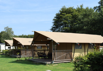 Safari tents with sanitary facilities at Familiepark de Vechtvallei in the Netherlands, green lawn.