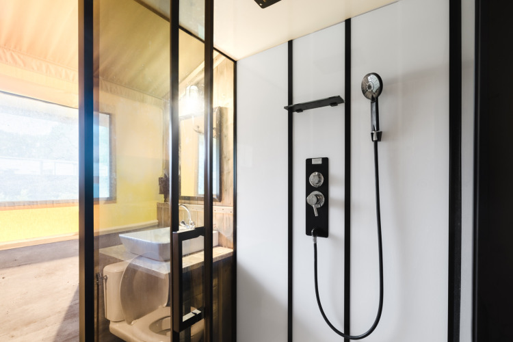 Moderne safaritent badkamer met douche, wastafel en toilet bij Familiepark de Vechtvallei, Nederland.