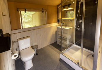 Modern sanitair in safaritent op Camping Emmen, Nederland, met douche, toilet en wastafel.