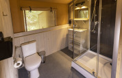 Modern sanitair in safaritent op Camping Emmen, Nederland, met douche, toilet en wastafel.