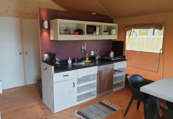 Angolo cucina interno in una tenda safari con comfort moderni al Camping Gorishoek nei Paesi Bassi.
