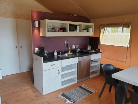Área de cocina interior en una tienda safari con comodidades modernas en Camping Gorishoek, Países Bajos.