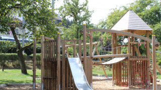 Speeltuin met houten klimrek en glijbaan op Camping Troisvierges, vakantiepark in Luxemburg.