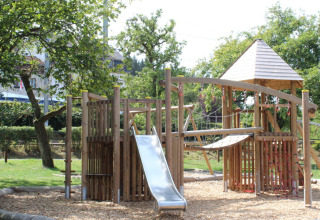 Speeltuin met houten klimrek en glijbaan op Camping Troisvierges, vakantiepark in Luxemburg.