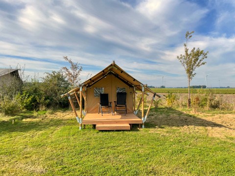 Safari tent Duolodge at Boerderijcamping de Hinde in the Netherlands, with two chairs on the porch.
