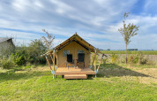 Safari tent Duolodge at Boerderijcamping de Hinde in the Netherlands, with two chairs on the porch.