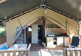 Vista di una tenda safari con servizi igienici a Camping De l'Olivigne, Francia. Terrazza e cucina all'aperto.