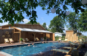 Udendørs swimmingpool med træstole og afslapningsområde på Camping Mareveld, Limburg, Holland om sommeren.