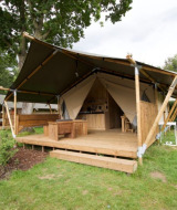 Tienda de lujo en Camping Mareveld, Limburg, Países Bajos, con terraza de madera y entorno natural.