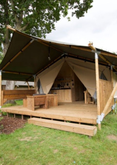 Tienda de lujo en Camping Mareveld, Limburg, Países Bajos, con terraza de madera y entorno natural.