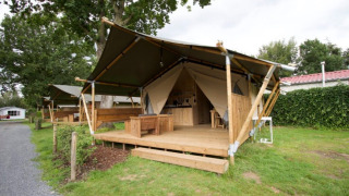 Tienda de lujo en Camping Mareveld, Limburg, Países Bajos, con terraza de madera y entorno natural.