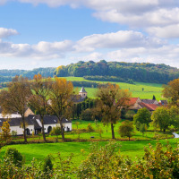 Vista pintoresca del entorno rural de Schimmert, Limburg, Países Bajos, con campos verdes y granjas.