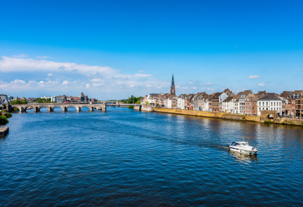 Vista de un río, un puente y casas pintorescas cerca de Schimmert, Limburgo, Países Bajos.