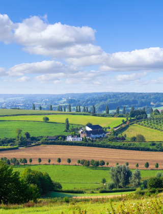 Foto del campo pintoresco cerca de Schimmert en Limburgo, Países Bajos, con colinas y campos verdes.