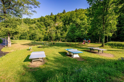 Spielplatz und Tischtennisplatten im Grünen im Ferienpark Camping l'Ardechois, Auvergne-Rhône-Alpes, Frankreich.