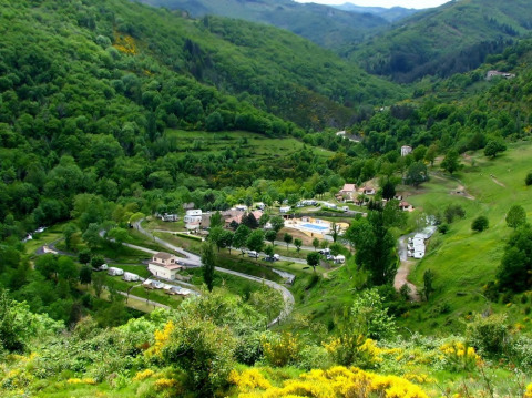 Vista panorámica del Camping l'Ardechois, rodeado de verdes colinas en Auvergne-Rhône-Alpes, Francia.