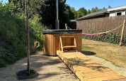 Buiten bubbelbad en houten toegangspad bij Veranda chalet met hangmat op Camping Sevink Molen, Nederland.