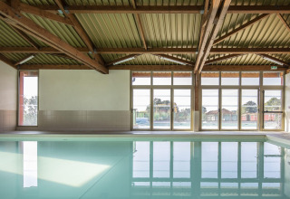 Heller Innenpool mit Holzbalkendecke und großen Fenstern im Arden Parks - Signy l'Abbaye, Grand Est, Frankreich.