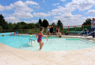 Børn og voksne nyder en solrig dag ved swimmingpoolen i Arden Parks Signy l'Abbaye, Grand Est, Frankrig.