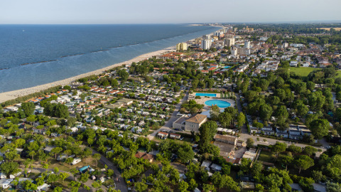 Vista aerea del Vigna sul Mar Family Camping Village sulla spiaggia in Emilia-Romagna, Italia, con piscine e verde.