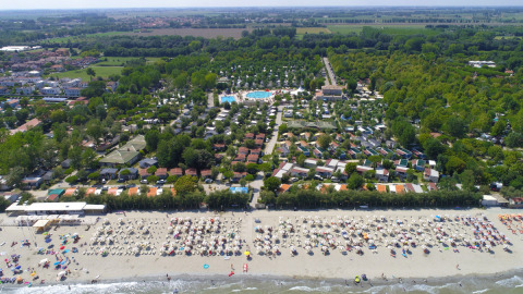 Vista aérea de Vigna sul Mar Family Camping Village con playa llena y sombrillas en Emilia-Romaña, Italia.