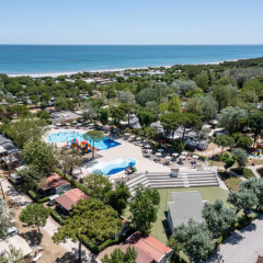 Vista aérea de Vigna sul Mar Family Camping Village en Emilia-Romagna, Italia, con piscina, árboles y playa.