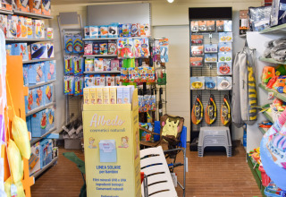 Toy and beach gear store with sunscreen, snorkels, and pool toys at a holiday park in Emilia-Romagna, Italy.
