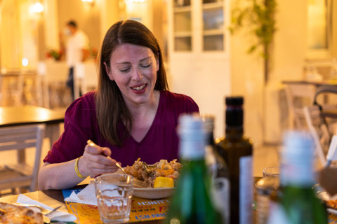 Mujer disfruta una cena en el restaurante de Vigna sul Mar Family Camping Village en Emilia-Romagna, Italia.