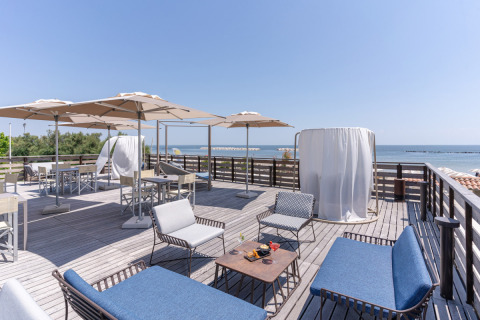 Terraza en la azotea con asientos cómodos, sombrillas y vista al mar en Vigna sul Mar Family Camping Village.