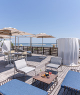 Terraza en la azotea con asientos cómodos, sombrillas y vista al mar en Vigna sul Mar Family Camping Village.
