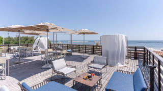 Terraza en la azotea con asientos cómodos, sombrillas y vista al mar en Vigna sul Mar Family Camping Village.