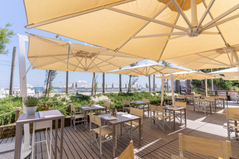 Terrasse de restaurant extérieure avec parasols au Vigna sul Mar Family Camping Village en Émilie-Romagne, Italie.