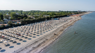 Vista aérea de la playa en Vigna sul Mar Family Camping Village en Emilia-Romaña, Italia, con sombrillas.