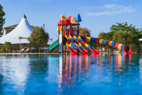 Colorful kids’ waterslide playground at Vigna sul Mar Family Camping Village, Emilia-Romagna, Italy.