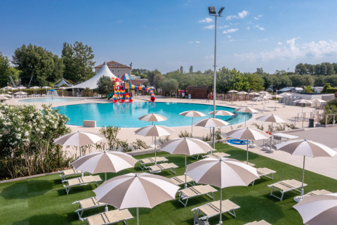 Área exterior de piscina con tumbonas y sombrillas en Vigna sul Mar Family Camping Village, Italia.