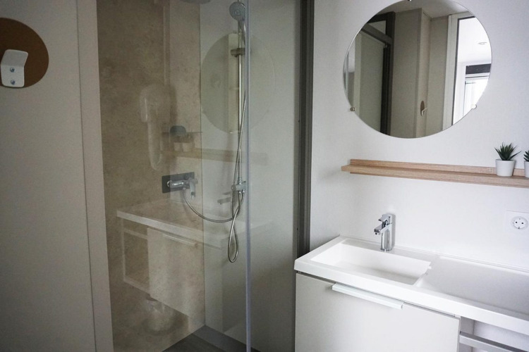 Baño moderno con ducha y lavabo blanco en Family Lodge del Holiday park De Boshoek en los Países Bajos.