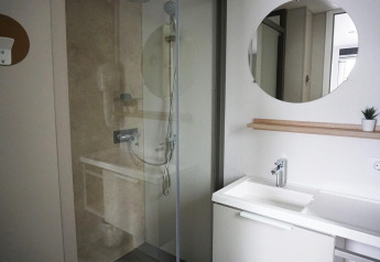 Bagno moderno con doccia e lavandino bianco presso Family Lodge all’Holiday park De Boshoek, Paesi Bassi.