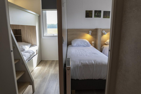 Familienzimmer in der Family Lodge im Holiday park De Boshoek, Niederlande, mit Einzel- und Etagenbetten.
