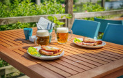 Outdoor table with two beers, sandwiches, and vegetables at Camping Prima holiday park in South-Bohemian, Czech Republic.