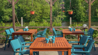 Espace extérieur avec chaises bleues et tables en bois au Camping Prima en Bohême du Sud, République tchèque.